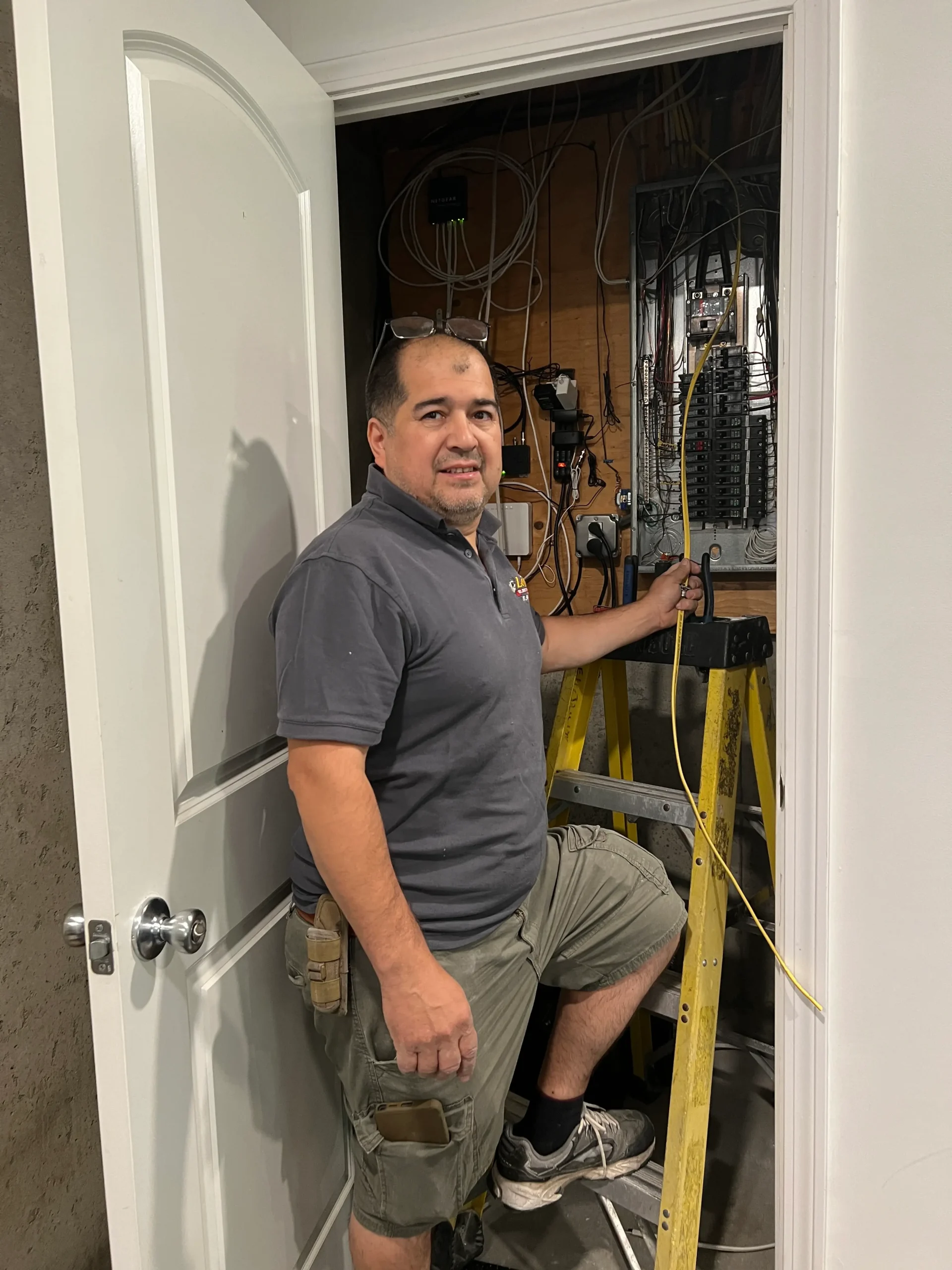 Julio Lopez servicing an electrical panel and adding new outlets and recess lights connections.