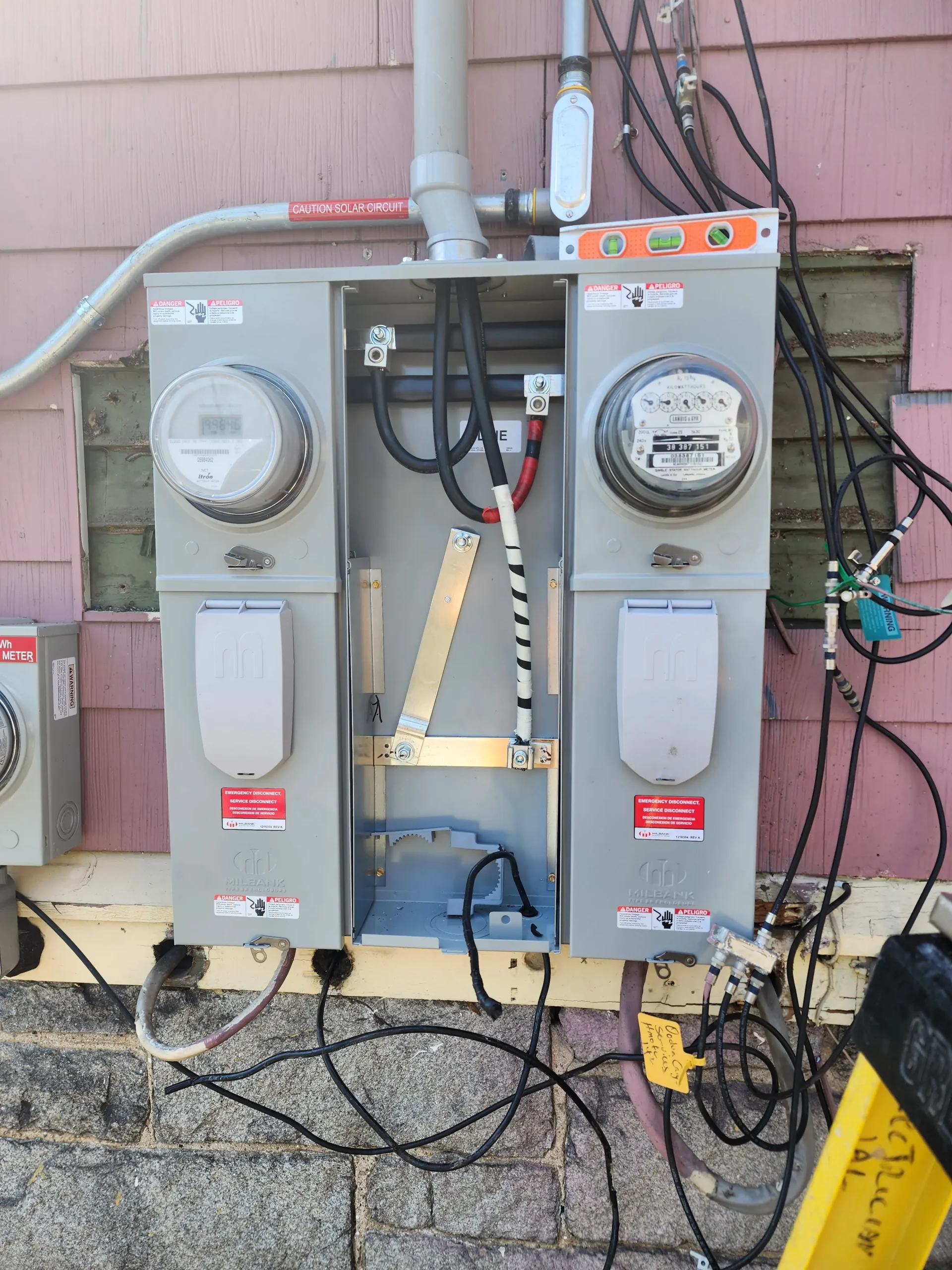 Two-family electrical meter service upgrade with exterior emergency disconnects and solar connection