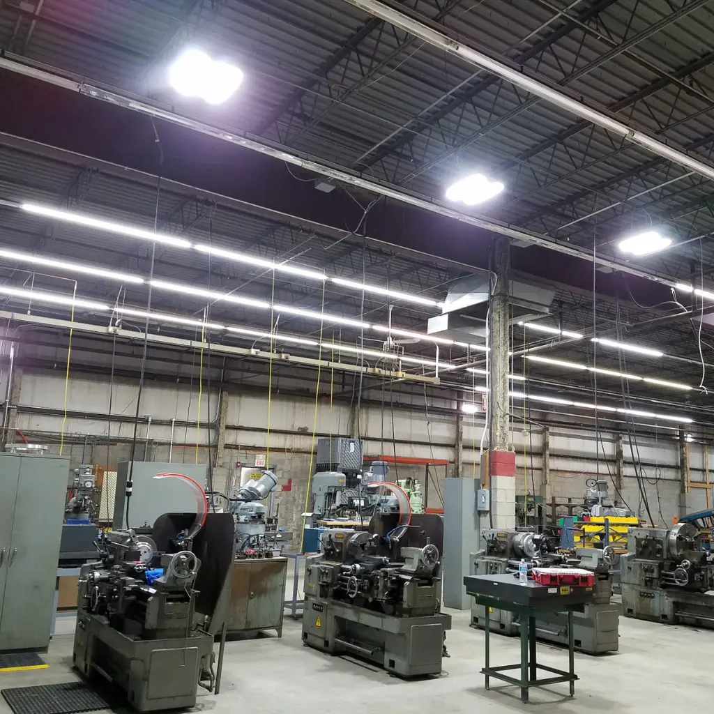 New LED high-bay lighting installed above manufacturing equipment on a shop floor