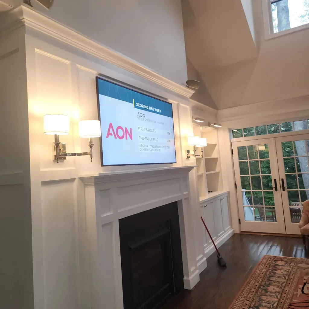 Finished fireplace TV installation with concealed wiring and wall sconces with the area all cleaned up.