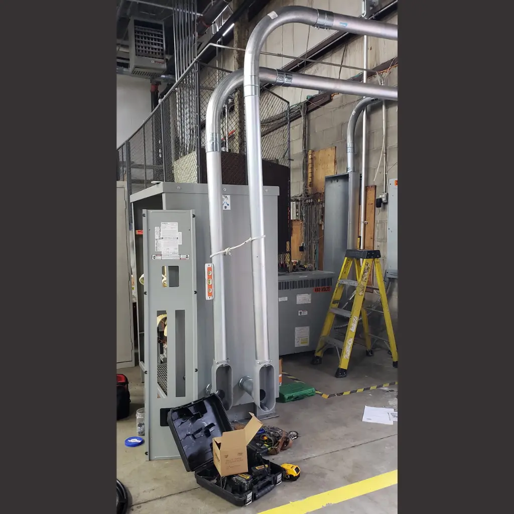 Industrial transformer installation with large metal conduit and electrical cabinets