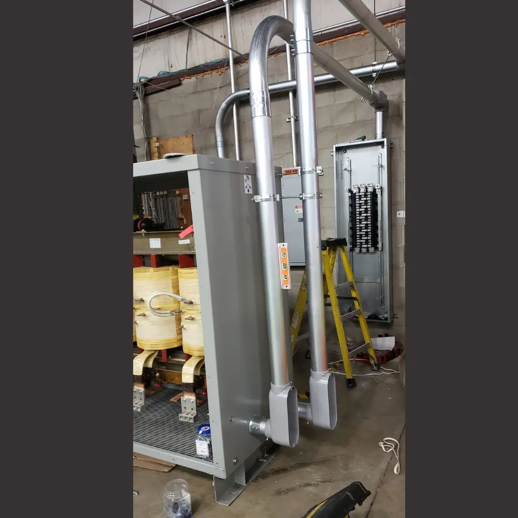 Commercial transformer with exposed coils, electrical wiring, and metal conduit