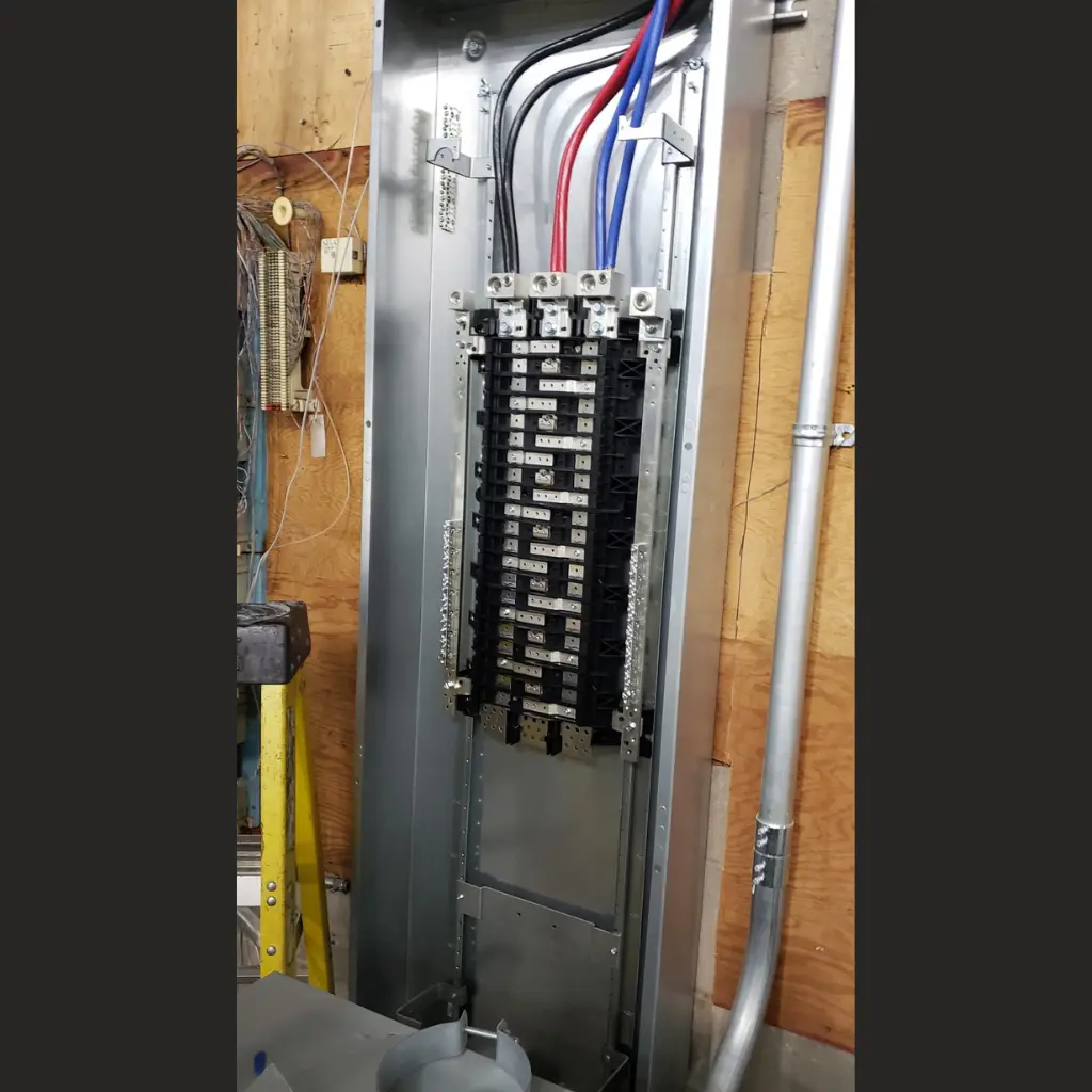 Open commercial electrical distribution panel with feeder cables and busbar assembly