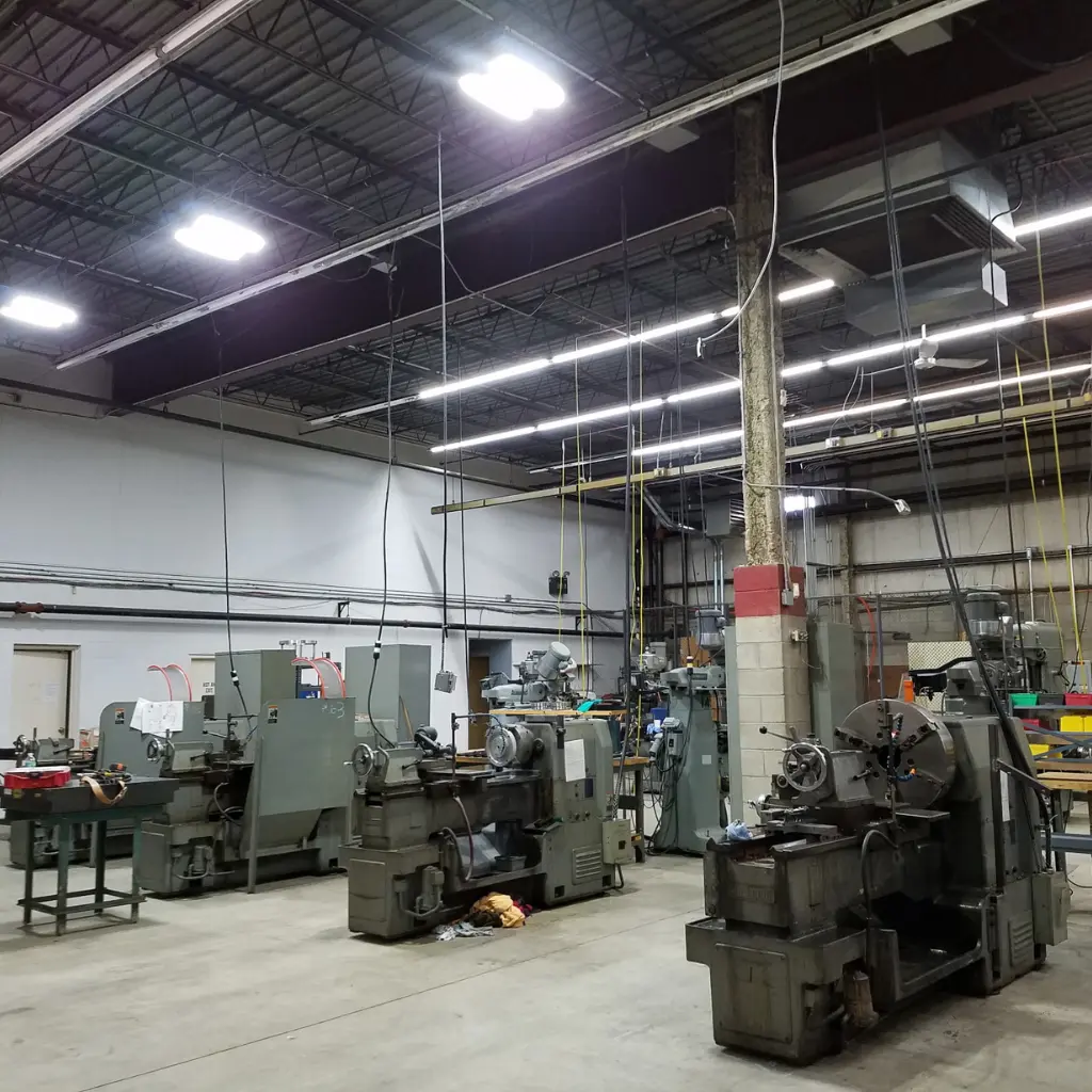 Bright overhead lighting installed above machinery in an industrial workshop