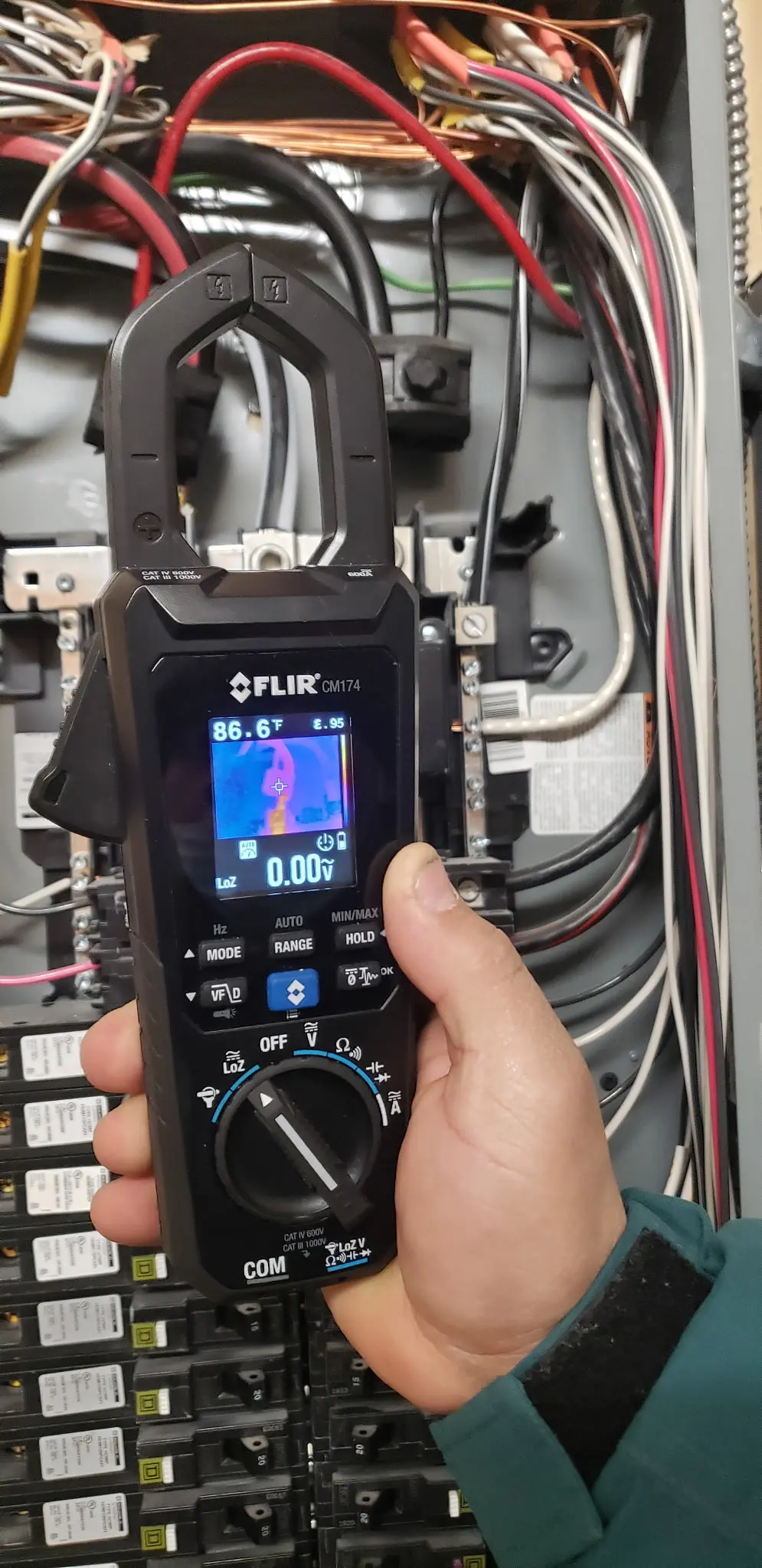 FLIR thermal imaging clamp meter checking wiring temperatures inside an electrical panel