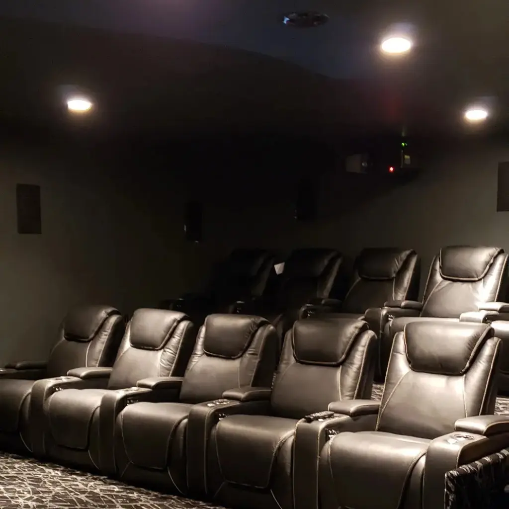 Finished home theater with recessed ceiling lighting above three rows of seating